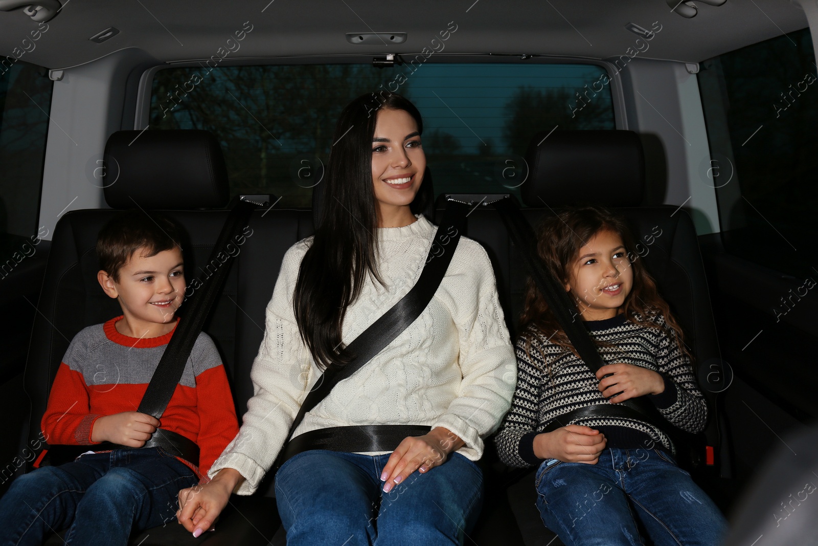 Photo of Mother with little children in modern car. Family trip