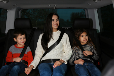 Photo of Mother with little children in modern car. Family trip