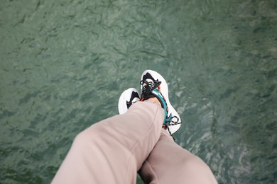 Man holding feet over water, top view