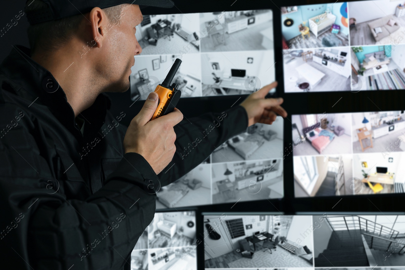 Photo of Security guard with portable transmitter monitoring modern CCTV cameras indoors