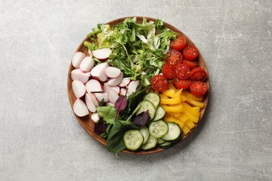 Photo of Vegetarian diet. Plate with tasty vegetables on light grey table, top view