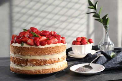 Photo of Tasty cake with fresh strawberries and mint served on gray table