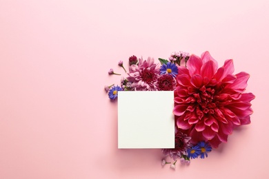 Flat lay composition with beautiful dahlia flowers and blank card on color background