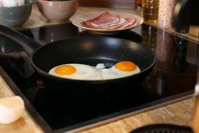 Frying eggs in kitchen for tasty breakfast