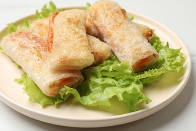 Photo of Delicious fried spring rolls on white table, closeup
