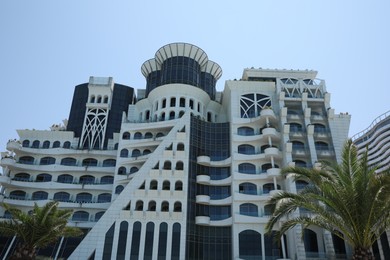 Photo of BATUMI, GEORGIA - JUNE 10, 2022: Beautiful Grand Gloria Hotel on sunny day, low angle view