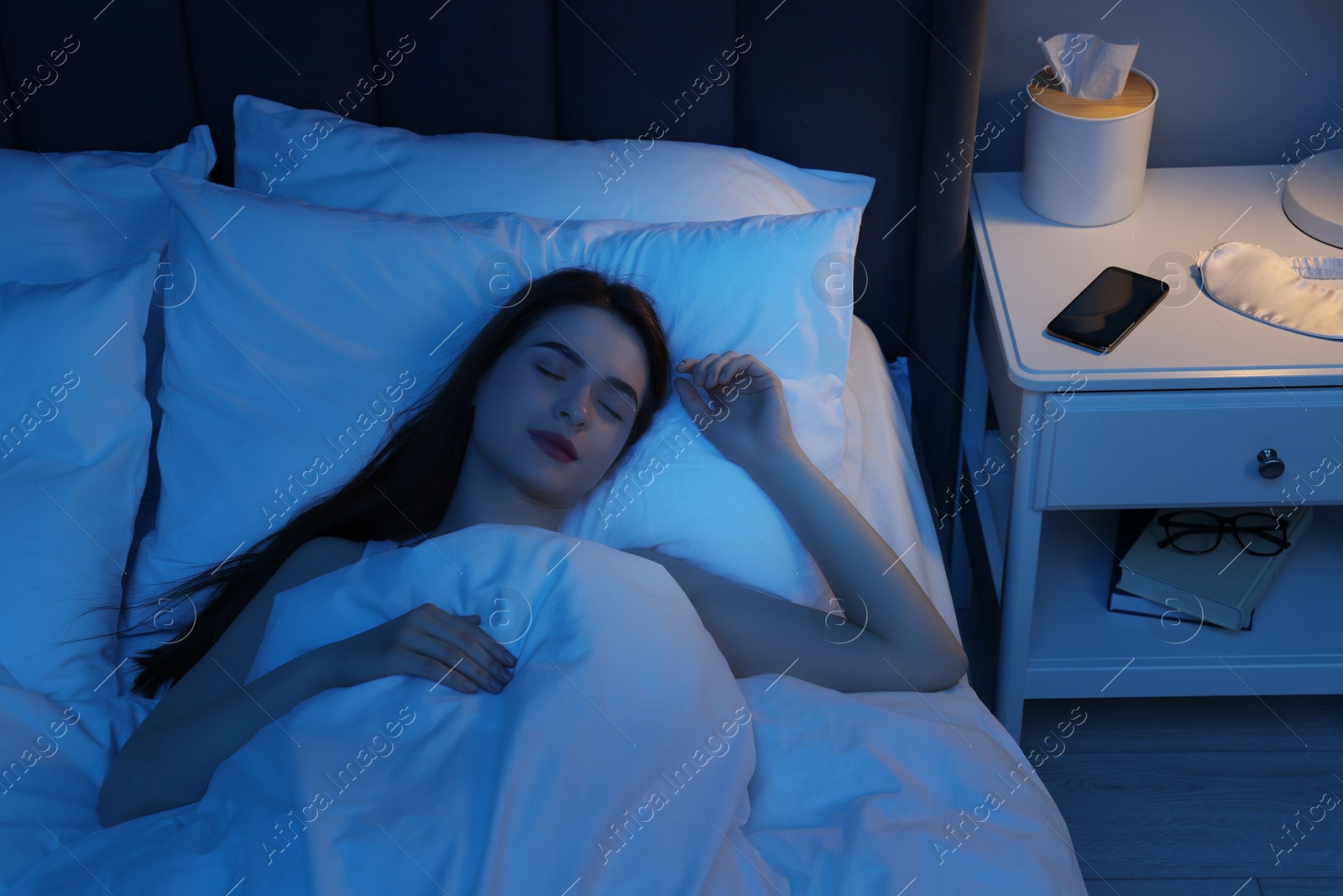 Photo of Beautiful young woman sleeping in bed at night