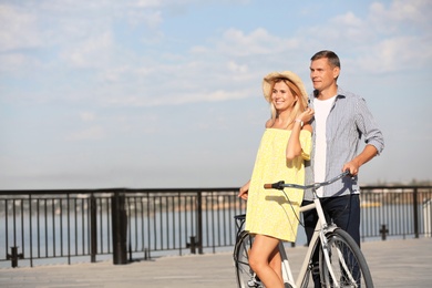 Happy couple with bicycle outdoors on sunny day