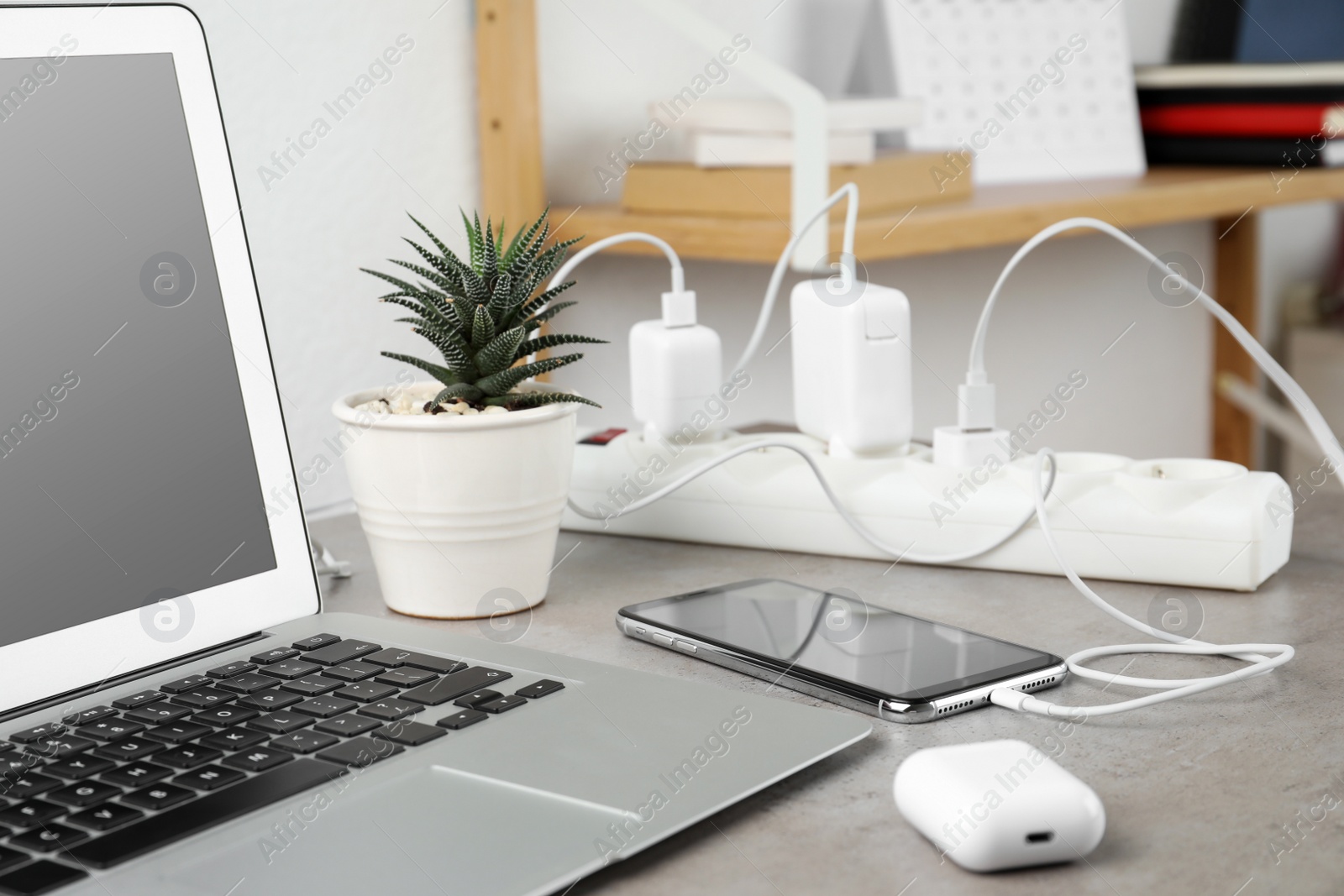 Photo of Smartphone charging with cable on light stone table