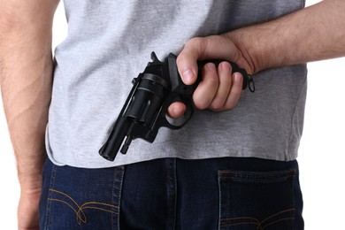 Man holding gun behind his back on white background, closeup