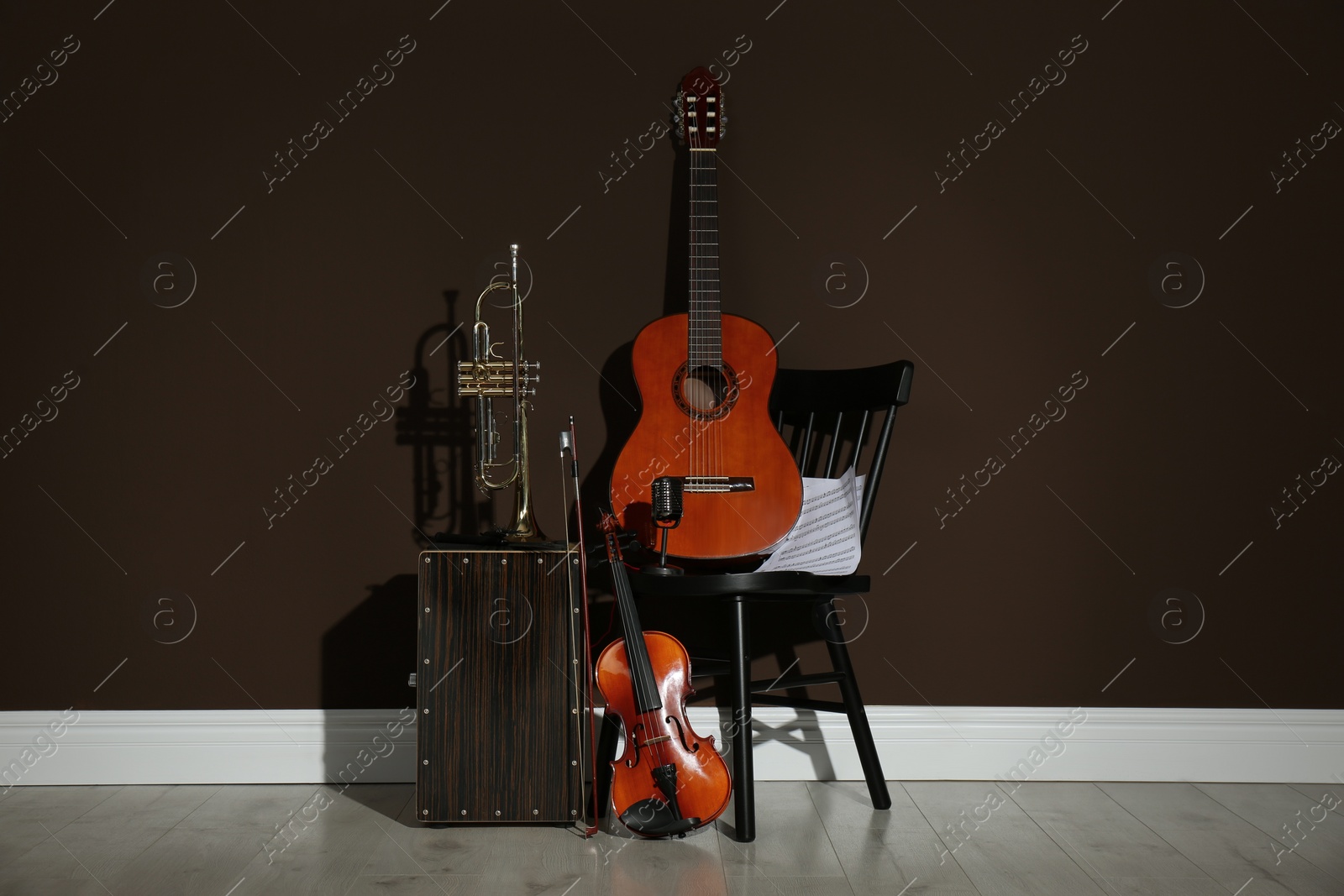 Photo of Set of different musical instruments near brown wall indoors