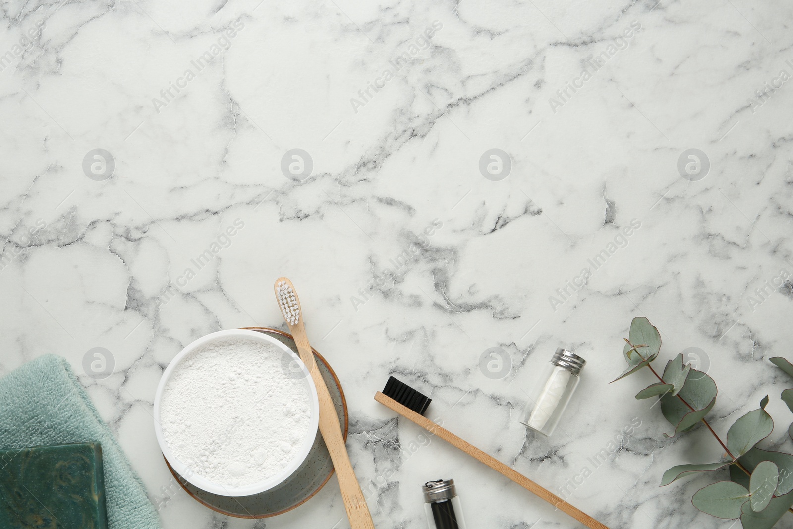 Photo of Flat lay composition with tooth powder and brushes on white marble table. Space for text
