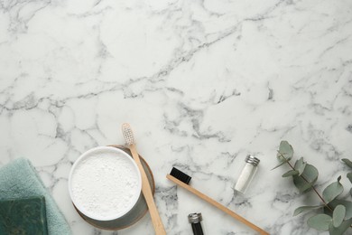 Flat lay composition with tooth powder and brushes on white marble table. Space for text