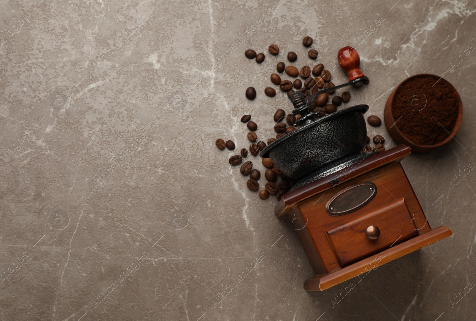 Photo of Vintage manual coffee grinder, powder and beans on grey table, flat lay. Space for text