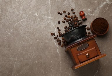 Vintage manual coffee grinder, powder and beans on grey table, flat lay. Space for text