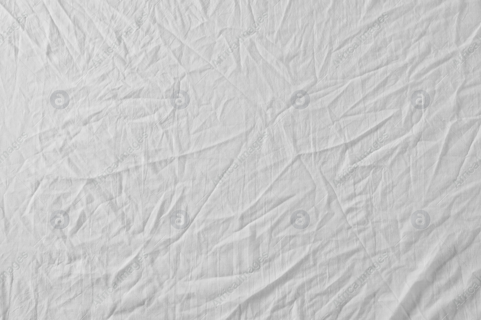 Photo of Crumpled white fabric as background, top view