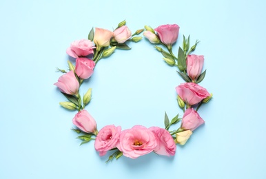 Photo of Frame of beautiful Eustoma flowers on light blue background, flat lay. Space for text