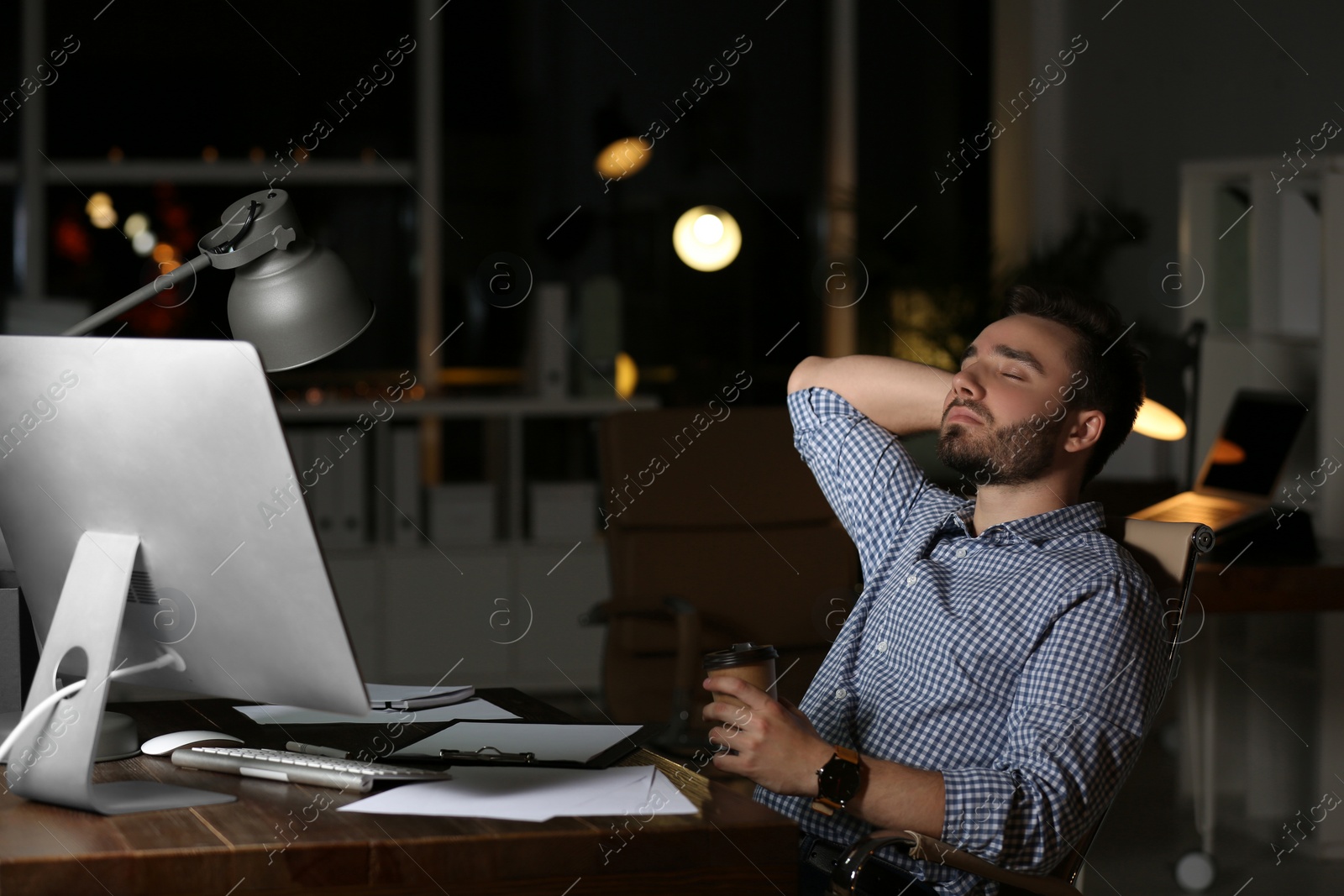 Photo of Young man working in office at night