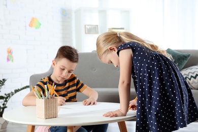 Photo of Cute little children drawing together at home