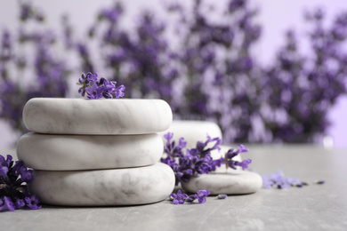 Photo of Stones, sea salt and lavender flowers on grey table
