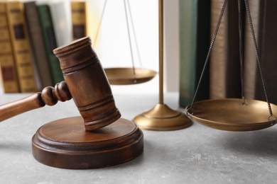 Wooden gavel, scales of justice and books on table. Law concept