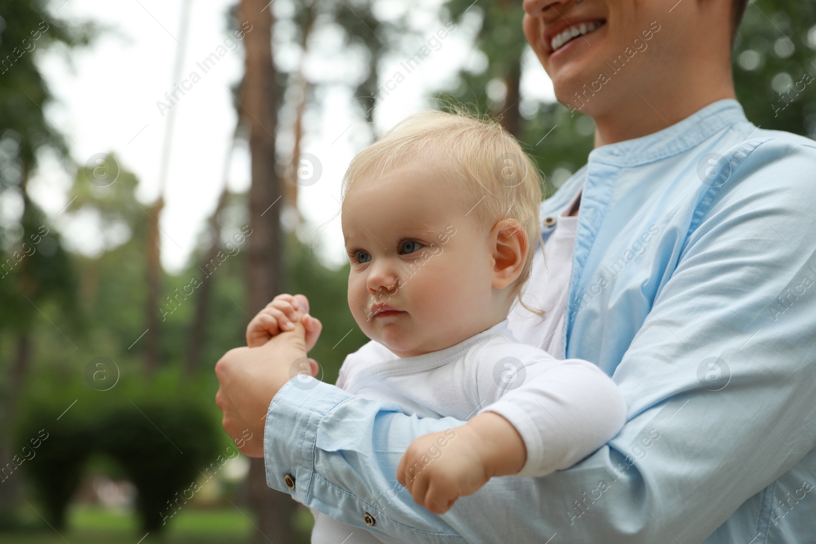 Photo of Father with his cute baby spending time together outdoors