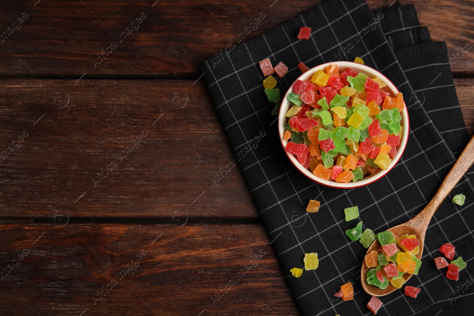 Photo of Mix of delicious candied fruits on wooden table, flat lay. Space for text