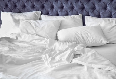 Comfortable bed with white linen at home