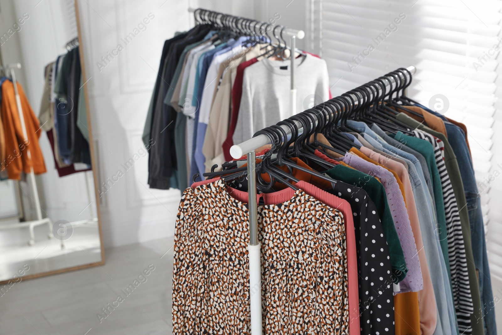 Photo of Racks with stylish clothes indoors. Fast fashion