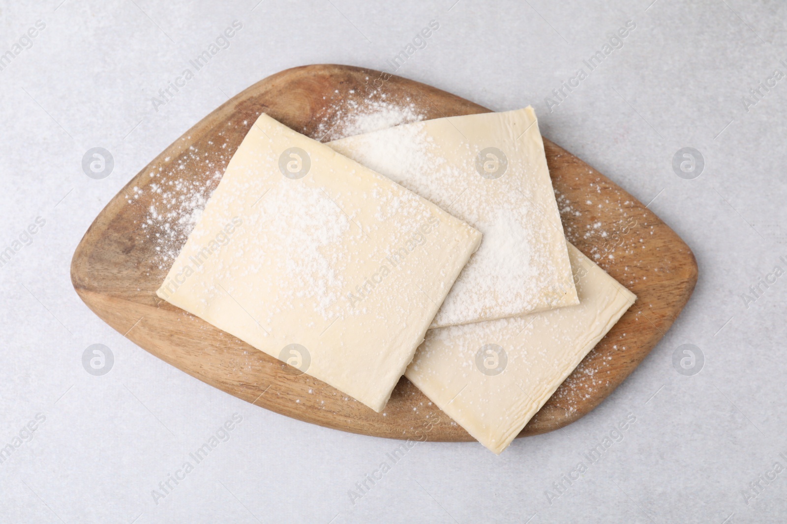 Photo of Raw puff pastry dough on white table, top view