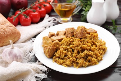 Photo of Delicious rice with chicken served on wooden table, closeup