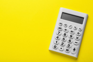 Photo of White calculator on yellow background, top view. Space for text