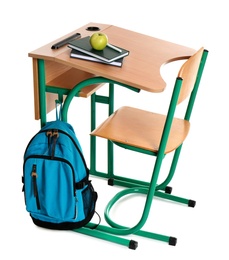 Photo of Wooden school desk with stationery, backpack and apple on white background