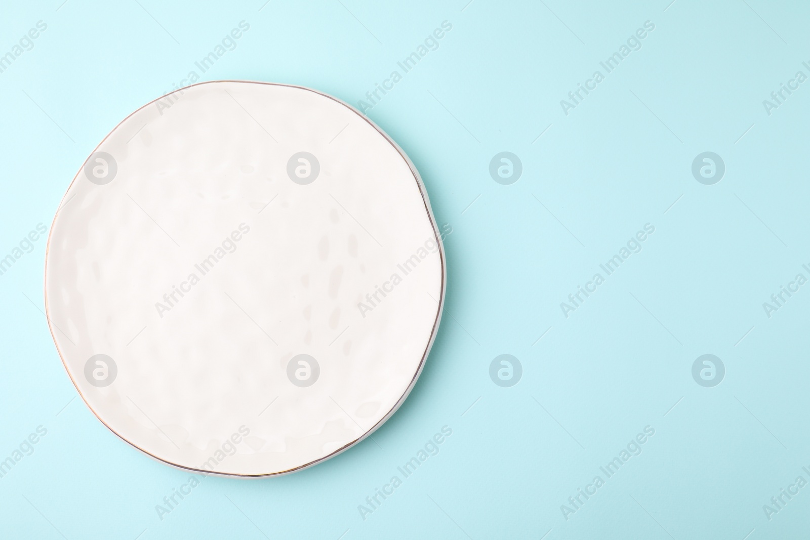 Photo of One clean plate on light blue background, top view. Space for text