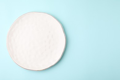 Photo of One clean plate on light blue background, top view. Space for text