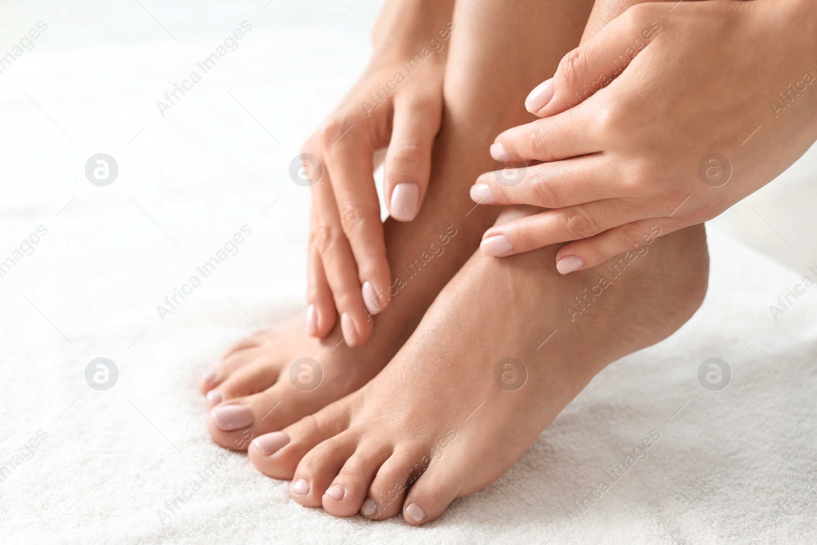 Photo of Woman with beautiful feet on white towel, closeup. Spa treatment