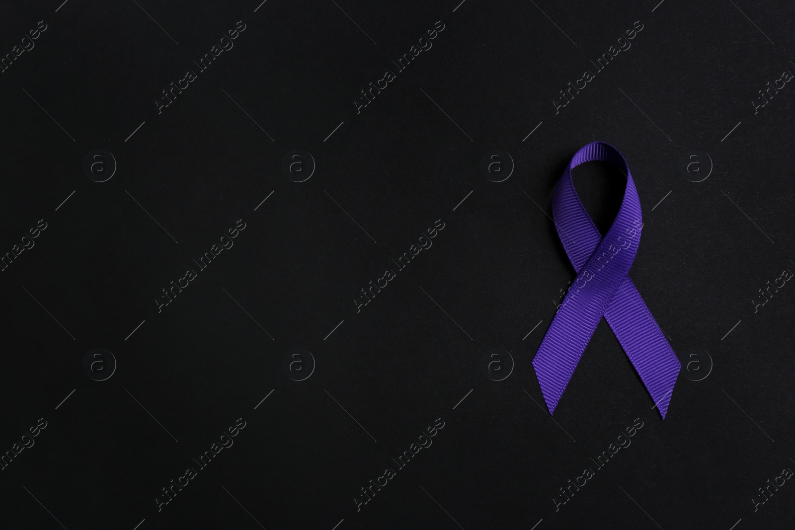 Photo of Purple awareness ribbon on black background, top view with space for text
