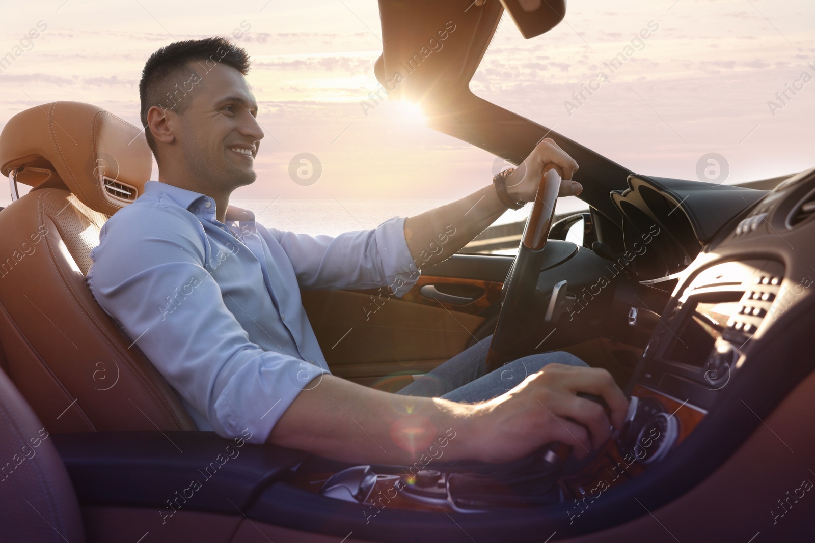 Photo of Businessman driving luxury convertible car outdoors on sunny day