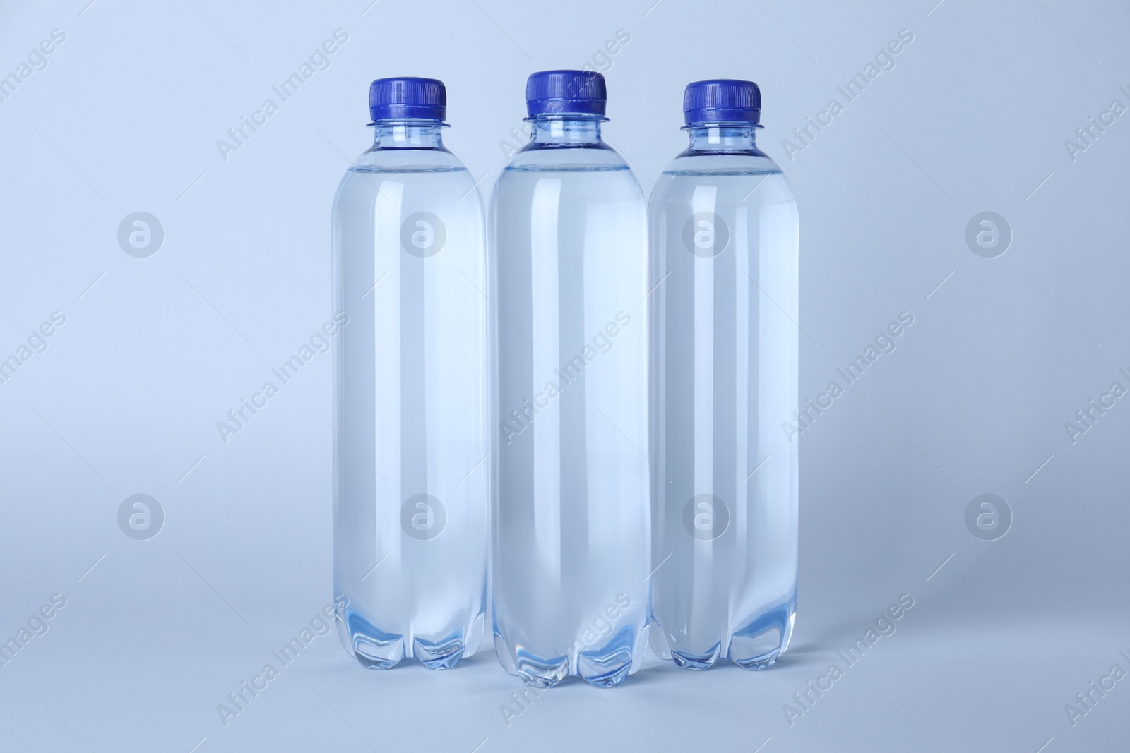 Photo of Plastic bottles with water on white background