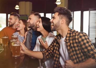 Photo of Group of friends watching football in sport bar