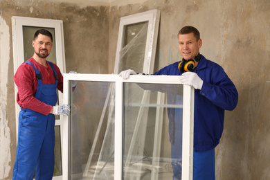 Workers in uniform with new plastic window indoors