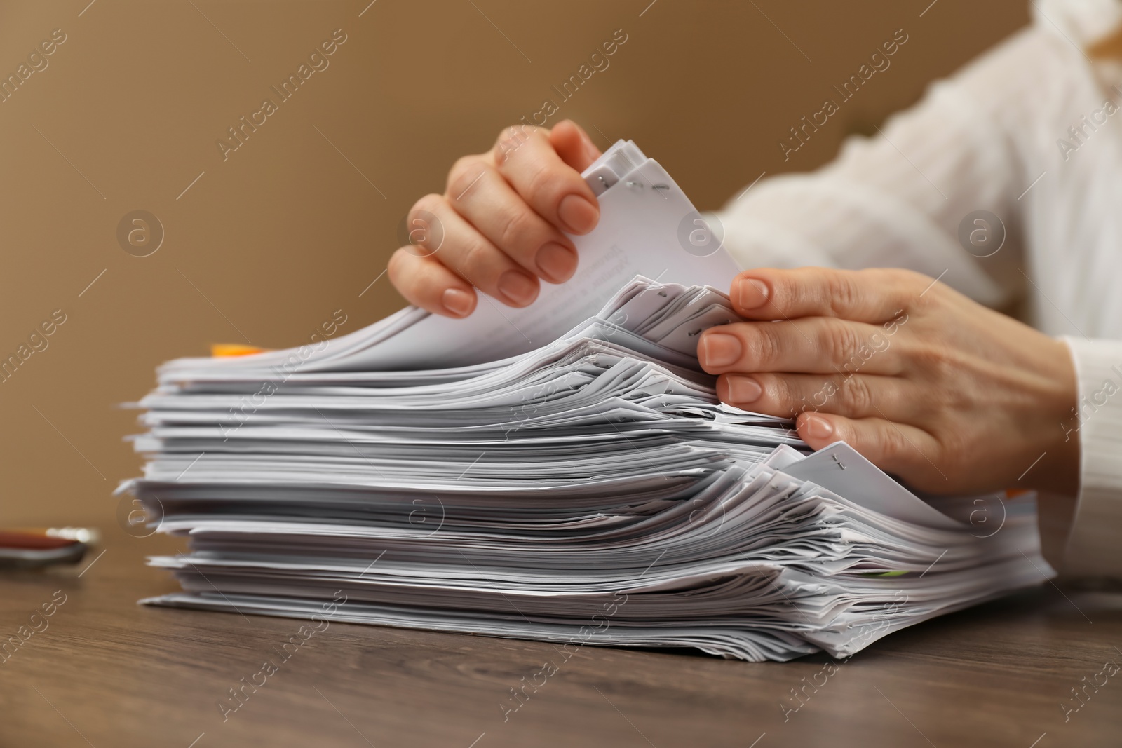 Photo of Woman stacking documents at wooden table indoors, closeup