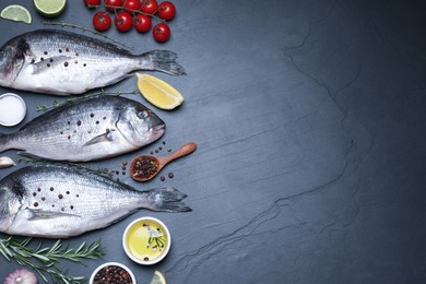Photo of Flat lay composition with fresh raw dorado fish and ingredients on black table, space for text