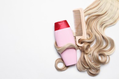 Photo of Lock of beautiful blonde curly hair, cosmetic product and comb on white background, top view