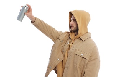 Photo of Handsome man holding can of spray paint on white background