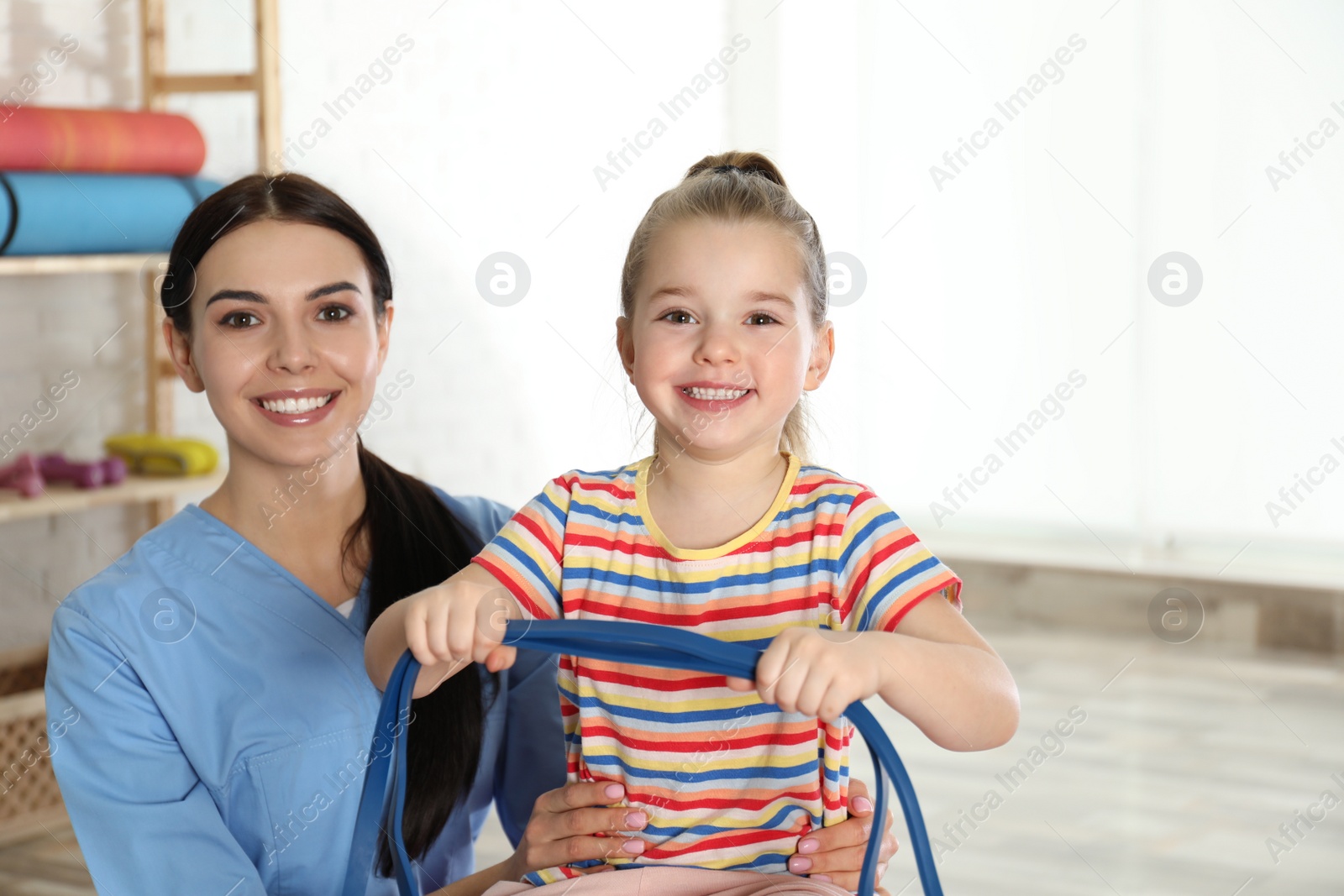 Photo of Orthopedist working with little girl in hospital gym