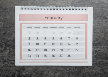 February calendar on grey stone background, top view