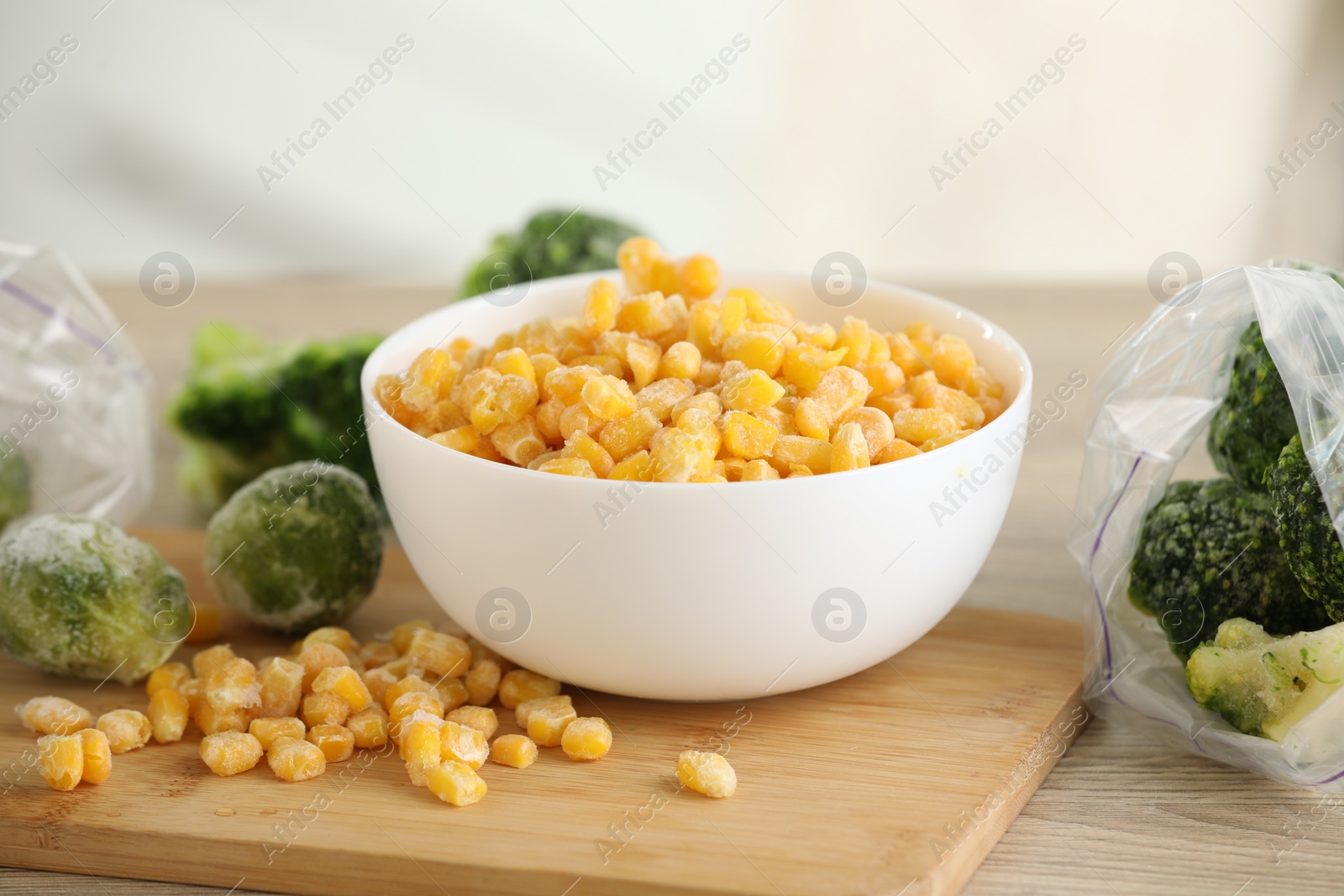 Photo of Frozen vegetables in bowl on wooden table, closeup