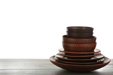 Photo of Different clay dishware on wooden table against white background