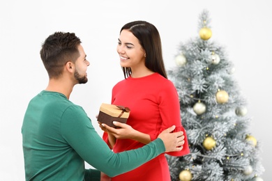 Happy young couple with Christmas gift at home